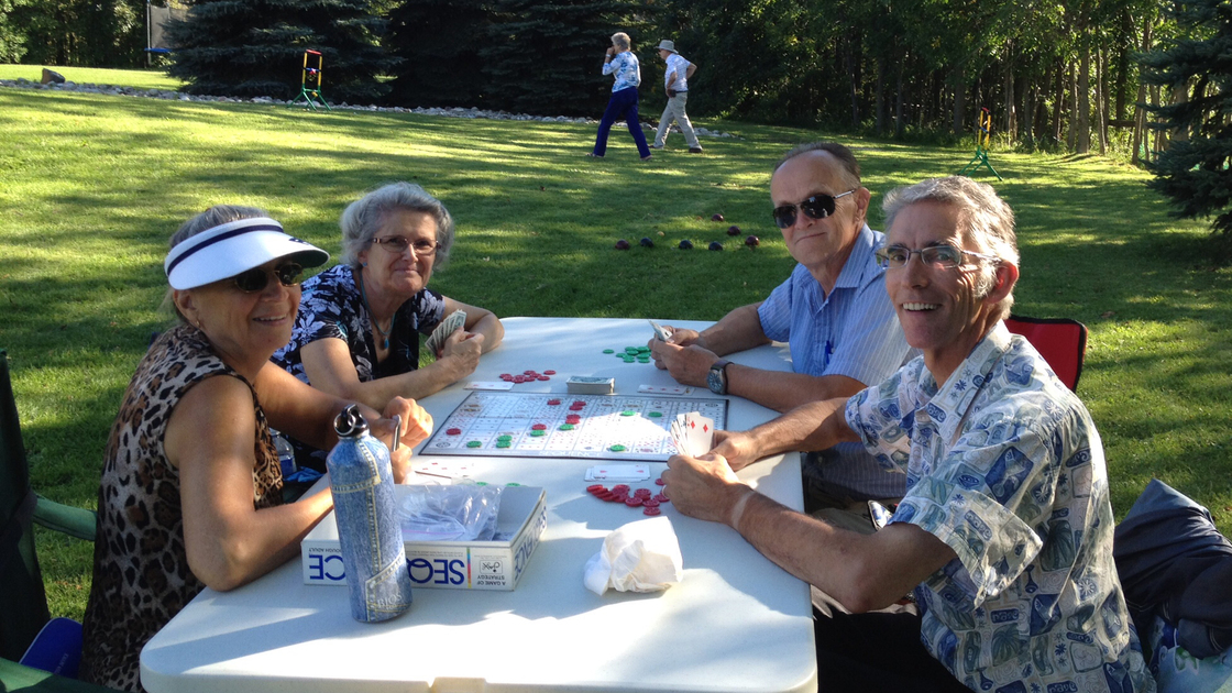Deaconess Elaine Armstrong, Theresa Gauvreau, David Robinson and Mike Gauvreau play board games outside.