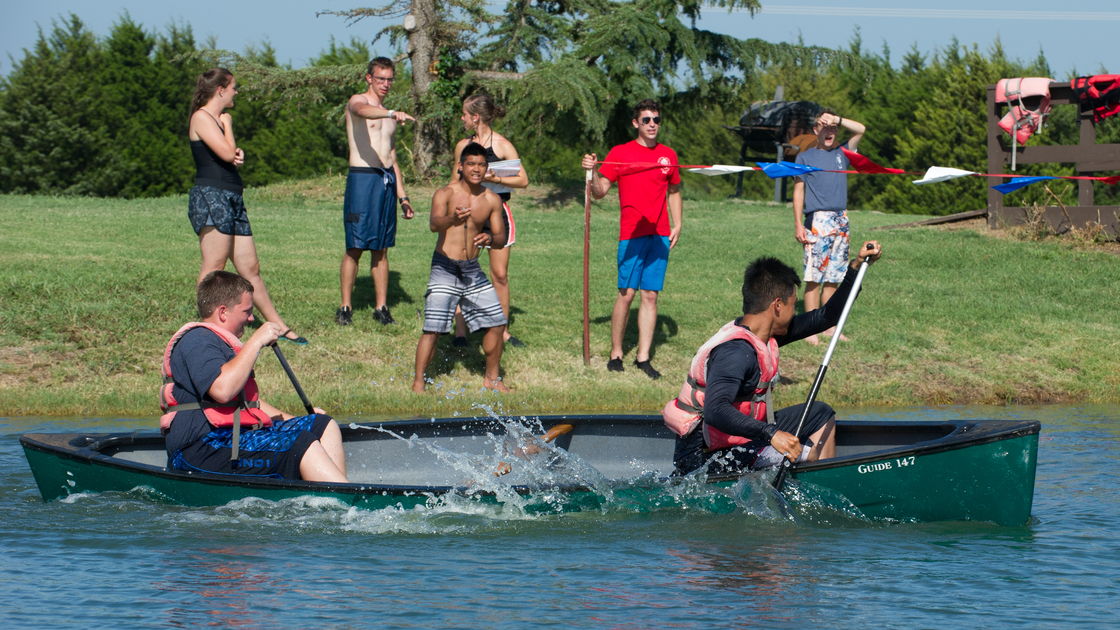 Justin Goodearl encourages  Wesley Campbell and Gino Chi as they race toward the finish line on the short course in canoeing.