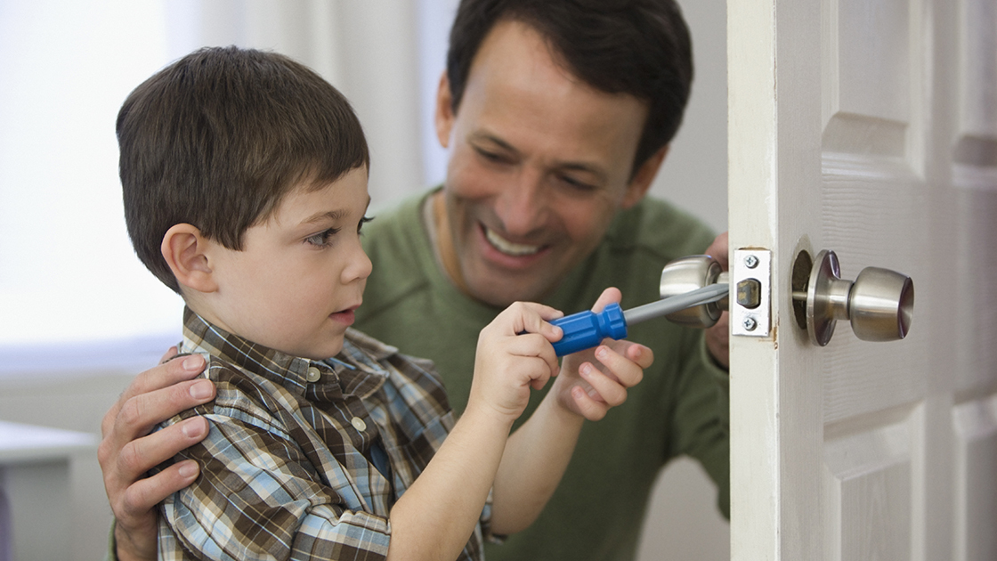 Father and son fixing doorknob