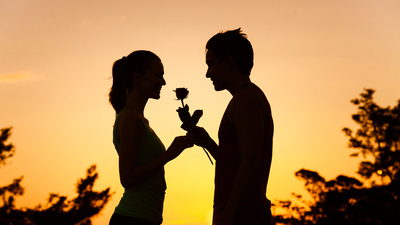 Man giving woman a rose. (romance and dating concepts)