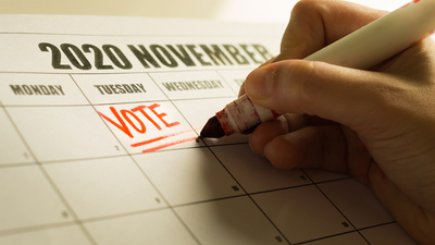 A american vote writing a reminder note on the calender to vote.